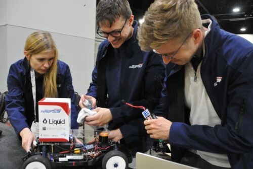 Team members are preparing the model race car and the software