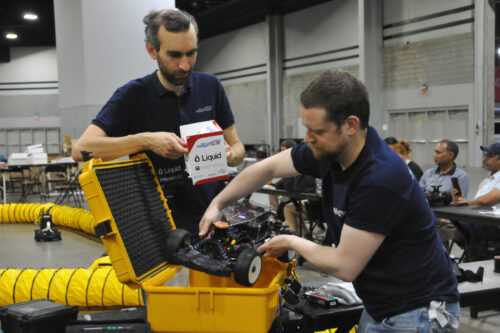 Team members are unpacking the model race car after international transport