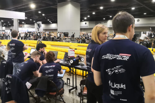 Team members are preparing the model race car and the software