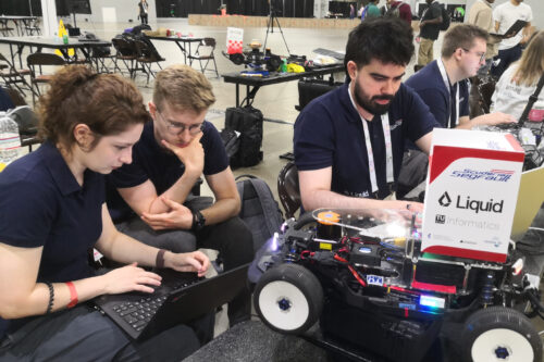 Team members are preparing the model race car and the software