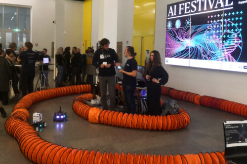 Racing car on the track on the ground with people looking at it.