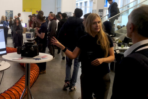 Team member talks to visitors and shows a racing car