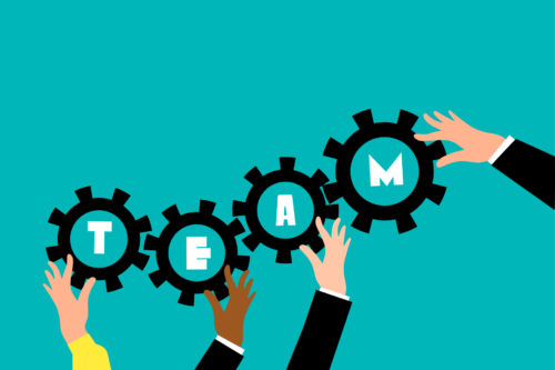 Four hands holding four gears up with the text "Team"