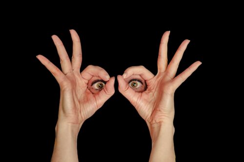 zwei Hände mit Zwei Augen in der Mitte