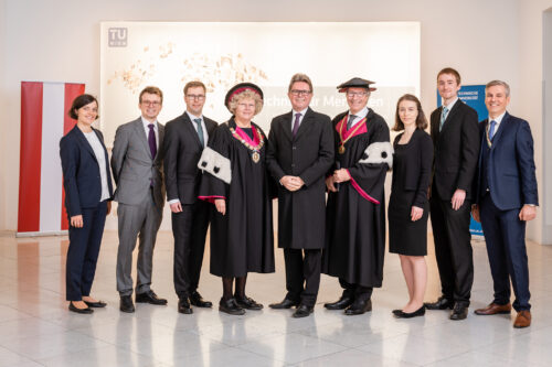 Gruppe stehend, im Hinetrgrund große Leinwand Theresia Knobloch, Robert Plachy, Alexander Toifl, Rektorin Sabine Seidler, Bundesminister Martin Polaschek, Vizerektor Kurt Matyas, Magdalena Schneider, Georg Hofstätter und Gerhard Freudenthaler (von links)