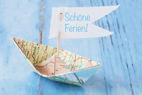 Gefaltetes Papierschiff mit Aufschrift 